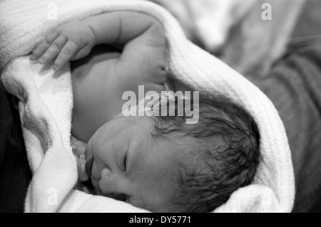 Photo en noir et blanc de Naissance bebe Fille enveloppé dans une couverture étant détenu par papa Banque D'Images