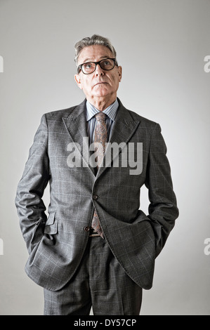 Senior man with hands in pockets, looking up Banque D'Images