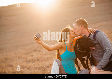 Kissing couple avec chien Banque D'Images