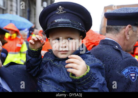 Dublin, Irlande. 7 avril 2014. Peu d'Owen (3) se trouve sur le bras de son père, portant son fire fighter's cap. Les pompiers de la Brigade des Pompiers de Dublin (DFB) ont protesté devant l'Hôtel de ville de Dublin pour le maintien de l'ambulance. Les propositions présentées par le conseil municipal de Dublin voir un examen et un éventuel déménagement du service à l'HSE (Health Service Executive) National Service d'ambulance. Crédit : Michael Debets/Alamy Live News Banque D'Images