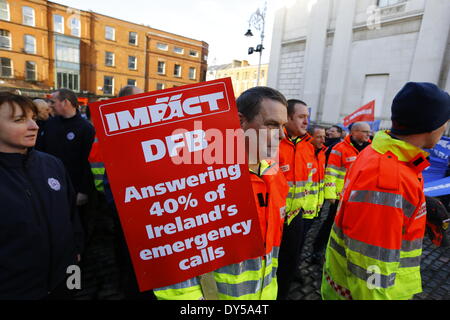 Dublin, Irlande. 7 avril 2014. Un pompier est titulaire d'une affiche qui se lit "IMPACT - DFB - Répondre à 40  % des appels d'urgence". Les pompiers de la Brigade des Pompiers de Dublin (DFB) ont protesté devant l'Hôtel de ville de Dublin pour le maintien de l'ambulance. Les propositions présentées par le conseil municipal de Dublin voir un examen et un éventuel déménagement du service à l'HSE (Health Service Executive) National Service d'ambulance. Crédit : Michael Debets/Alamy Live News Banque D'Images