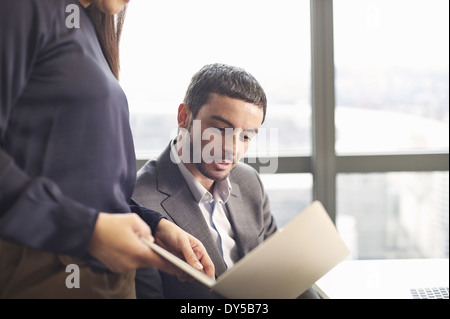 Des collègues d'affaires à la recherche d'idées on laptop in office Banque D'Images