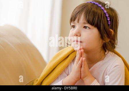 Young Girl sitting on sofa daydreaming Banque D'Images