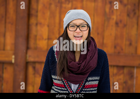 Portrait de jeune femme en face de clôture en bois Banque D'Images