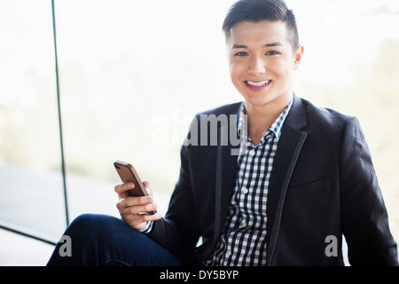 Portrait of young businessman holding smartphone Banque D'Images
