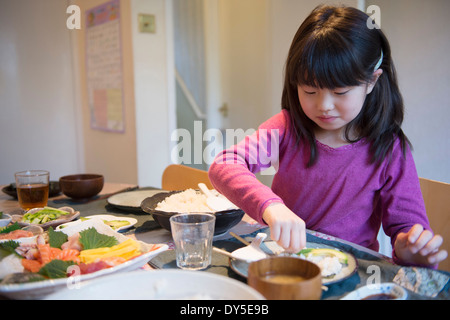 Girl selecting repas à partir de plats sur table à manger Banque D'Images