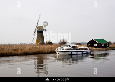 Moulin de drainage St Benets sur la rivière Thurne avec une embarcation de plaisance en passant en face Banque D'Images