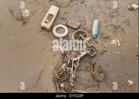 Les objets jetés au rebut cachés découverts à marée basse à l'estuaire de la Tamise couvert de boue film algues limon Banque D'Images