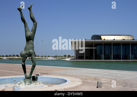 Statue d'une Pearl Diver au Musée National de Bahreïn Bahreïn avec le Théâtre National de l'arrière-plan, Royaume de Bahreïn Banque D'Images