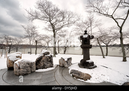 WASHINGTON DC, États-Unis — la lanterne japonaise, un objet historique en pierre, est voilée dans la neige au bassin de Tidal à Washington, D.C. Cette scène hivernale met en lumière l'endurance et l'importance historique de la Lanterne, qui est un symbole d'amitié entre le Japon et les États-Unis. Banque D'Images