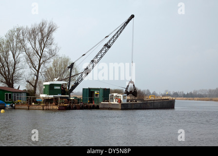 Par dragage Broads Authority sur la rivière Thurne à Norfolk Banque D'Images