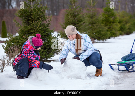 La mère et l'enfant heureux bonhomme de bâtiment dans winter park Banque D'Images