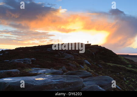 Personne sur les roches de Stanage Edge avec le lever du soleil d'hiver, près de Hathersage, parc national de Peak District, Derbyshire, Angleterre, RU Banque D'Images