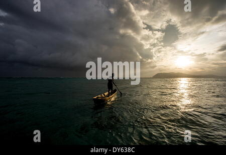 Un homme dans un canot creusé au coucher du soleil, les Îles Salomon, Pacific Banque D'Images