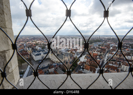 BRUGES, Belgique — Une vue panoramique sur la ville médiévale de Bruges depuis le sommet du beffroi du XIIIe siècle révèle le paysage urbain historique. Le niveau d'observation, atteint après avoir gravi 366 marches, offre des vues spectaculaires sur le centre-ville médiéval bien préservé. De cette hauteur, les visiteurs peuvent observer les toits de tuiles rouges caractéristiques et les flèches qui définissent l'horizon historique de Bruges. Banque D'Images