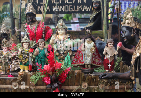 Homme noir avec statuettes sainte et poupées, Ati Atihan Festival, Kalibo, Aklan, région Western Visayas, l'Île Panay, Philip Banque D'Images