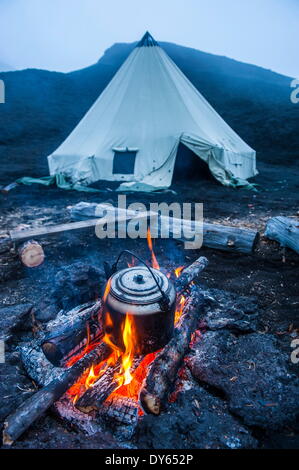 Pot à eau bouillante sur un feu ouvert sur un camping et tipis sur volcan Tolbachik, du Kamtchatka, la Russie, l'Eurasie Banque D'Images