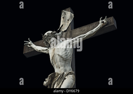 Crucifixion. Jésus Christ crucifixion statue isolé sur fond noir. Banque D'Images