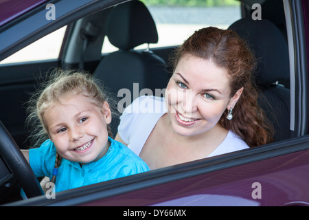 Mère avec sa jeune fille, assis sur le siège conducteur en voiture Banque D'Images