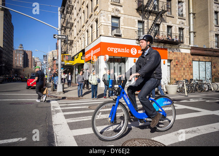 Un Citibike rider passe un magasin Avenue organique dans le quartier de Chelsea, New York Banque D'Images