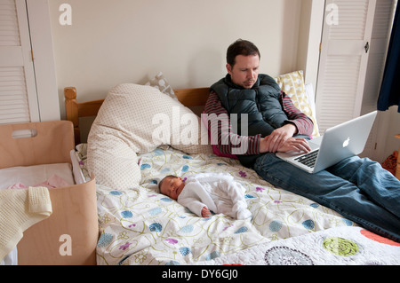 Père avec son bébé nouveau-né sur un lit à la peur Banque D'Images