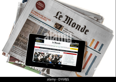 Tablette numérique à écran tactile en ligne montrant les nouvelles du monde sur le dessus du français au journal Le Monde sur fond blanc Banque D'Images