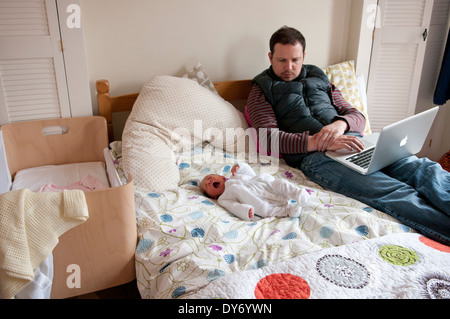 Père avec son bébé nouveau-né sur un lit à la peur Banque D'Images