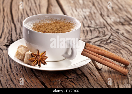 Tasse de cappuccino décoré avec des épices et des cubes de sucre brun près de lui. Banque D'Images