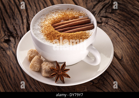 Tasse de cappuccino décoré avec des épices et des cubes de sucre brun près de lui. Banque D'Images