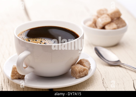 Tasse de café avec des morceaux de sucre sur la vieille table en bois. Banque D'Images