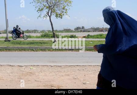 Islamabad, Pakistan. 8 avril, 2014. Un réfugié afghan femme fait le chemin du retour chez elle dans le bidonville d'Islamabad le 8 avril 2014. Selon l'Organisation des Nations Unies pour les réfugiés, le HCR, il y a environ 2,6 millions d'Afghans au Pakistan, dont la plupart vivent ici depuis le début des années 1980 lorsque l'ancien Union soviétique a envahi leur pays. Avec peu d'occasions de faire leur vie au Pakistan, ils veulent retourner chez eux mais seulement après la paix est rétablie en Afghanistan. Credit : PACIFIC PRESS/Alamy Live News Banque D'Images