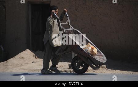 Islamabad, Pakistan. 8 avril, 2014. Un réfugié afghan boy utilise une wheelburrow d'apporter les briques dans le bidonville d'Islamabad le 8 avril 2014. Selon l'Organisation des Nations Unies pour les réfugiés, le HCR, il y a environ 2,6 millions d'Afghans au Pakistan, dont la plupart vivent ici depuis le début des années 1980 lorsque l'ancien Union soviétique a envahi leur pays. Avec peu d'occasions de faire leur vie au Pakistan, ils veulent retourner chez eux mais seulement après la paix est rétablie en Afghanistan. Credit : PACIFIC PRESS/Alamy Live News Banque D'Images