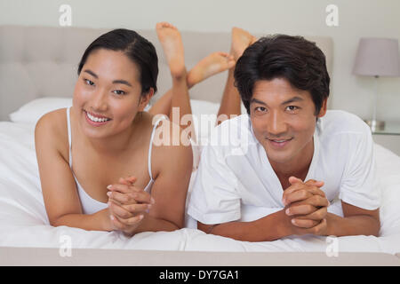 Heureux couple lying on bed together Banque D'Images