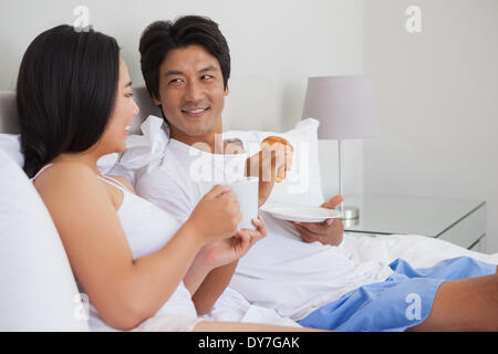 Heureux couple having breakfast in bed Banque D'Images