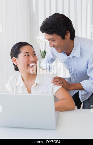 Happy couple using laptop Banque D'Images