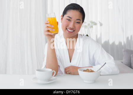 Happy woman in bathrobe avoir son petit-déjeuner Banque D'Images