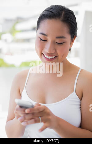 Asian woman texting on phone Banque D'Images