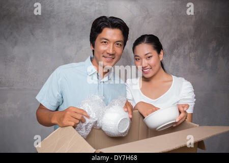 Heureux couple unpacking moving boxes Banque D'Images