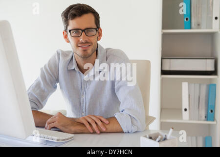 Businessman smiling at camera à son bureau. Banque D'Images