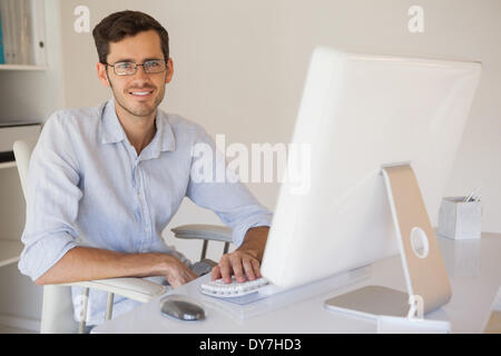 Businessman smiling at camera à son bureau. Banque D'Images