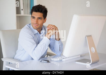 Businessman smiling at his desk Banque D'Images