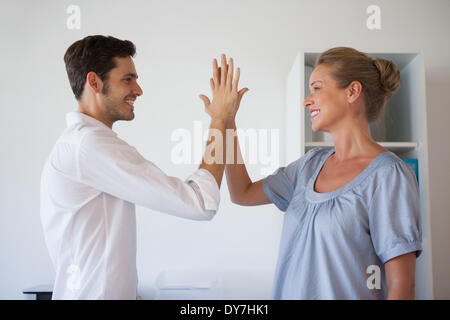 L'équipe d'affaires occasionnels high fiving Banque D'Images