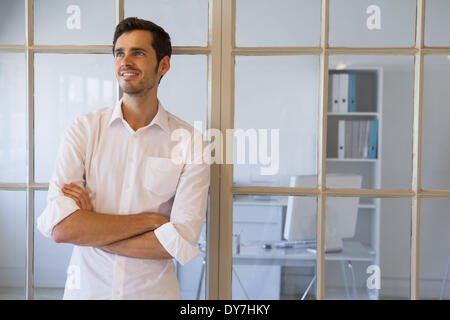 Businessman smiling with arms crossed Banque D'Images