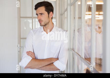 Casual upset businessman leaning against window Banque D'Images