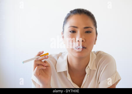 Femme d'occasionnels Fumeurs une cigarette électronique Banque D'Images