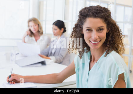 Casual businesswoman smiling at camera during meeting Banque D'Images