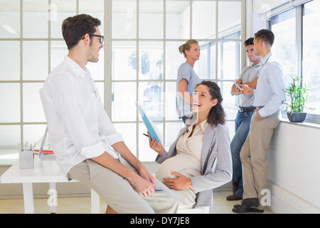 Businesswoman laughing avec collègue enceinte Banque D'Images