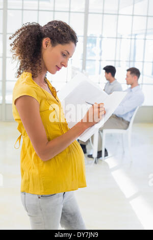 Enceintes Casual businesswoman writing in folder Banque D'Images