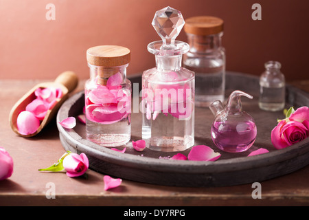 L'alchimie et l'aromathérapie avec des fleurs rose et flacons Banque D'Images