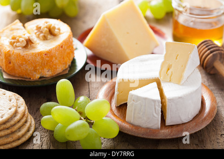 Différents types de fromage aux raisins, miel et noix Banque D'Images